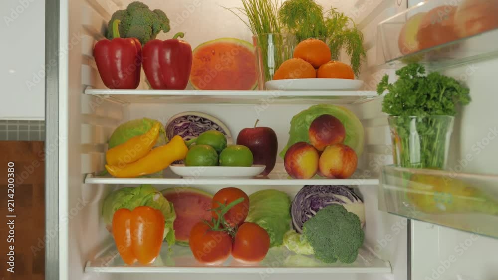 Refrigerator is open to reveal that it's full with fruits and veggies Refrigerator is open to reveal that it's full with fruits and veggies