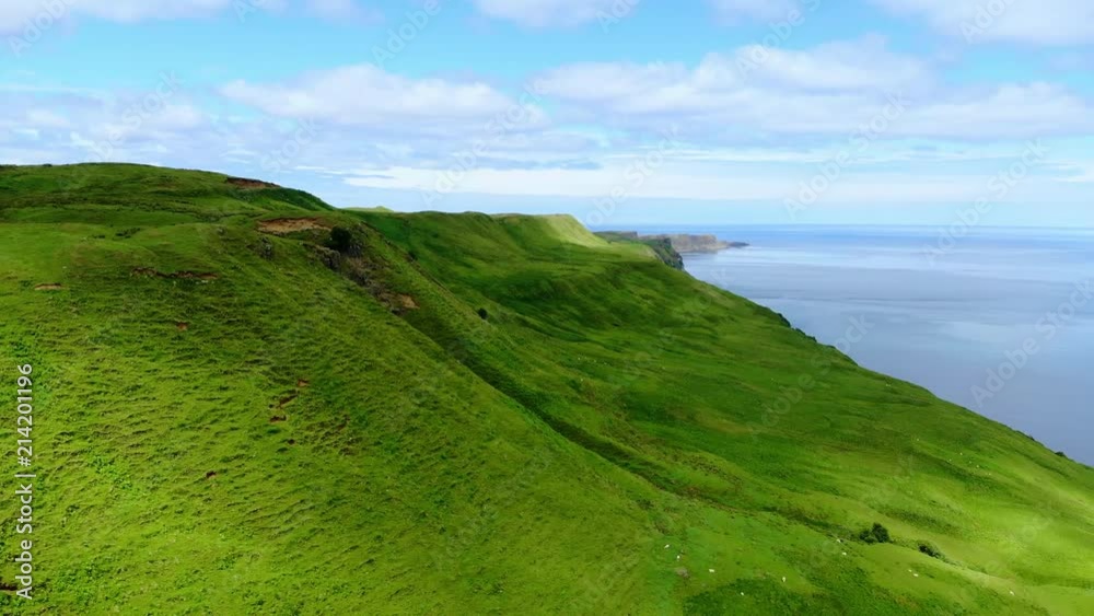 Flight over the green coastline and cliffs on the Isle of Skye in Scotland Flight over the green coastline and cliffs on the Isle of Skye in Scotland