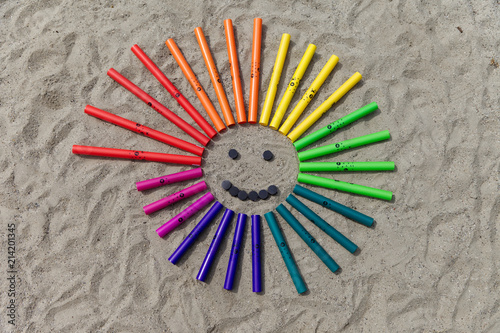 Boomwhackers in form of a smile in the sand