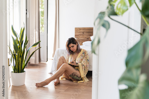 Pretty woman sketching near bed