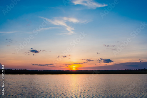 Sunset in the lake. beautiful sunset behind the clouds above the over lake landscape background. dramatic sky with cloud at sunset