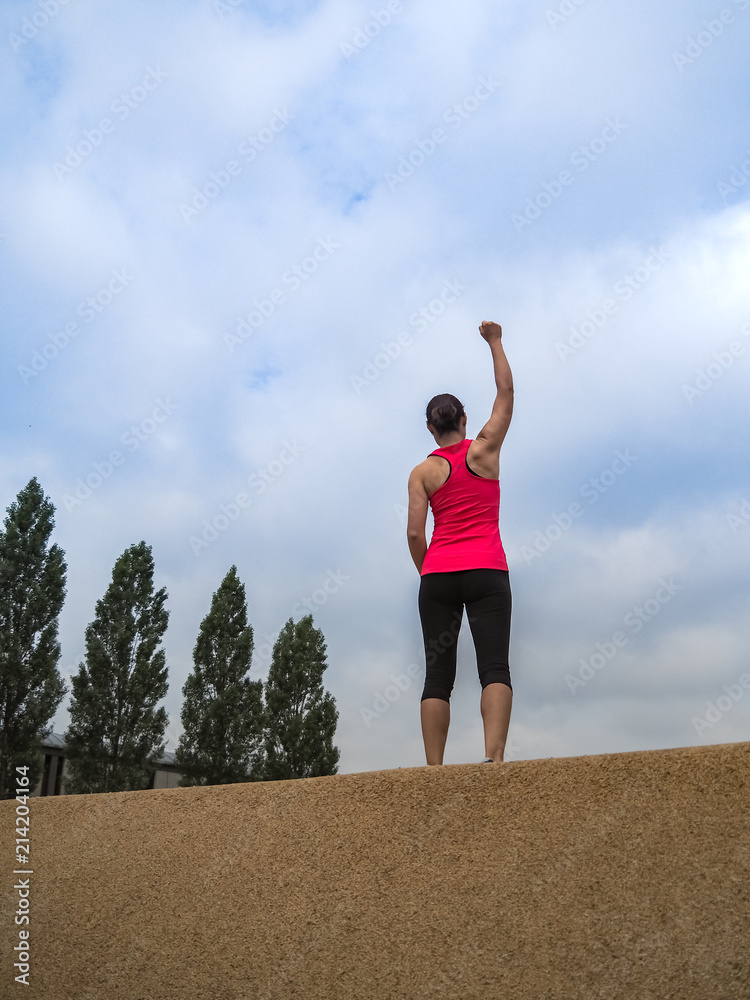 triumphant Fitness WOMAN standing IN YES POSE and making fists after workout
