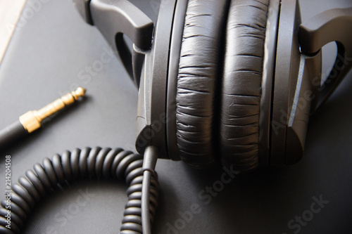 Musical equipment, Professional studio black headphones and jack cord. Close up from above