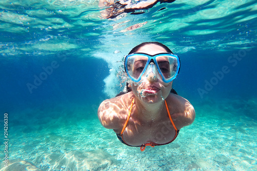 Beautiful young woman diving underwater in the sea
