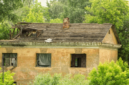 old ruined house among green trees photo