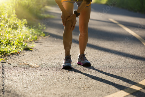 Fototapeta Naklejka Na Ścianę i Meble -  fitness young woman runner with sports injured knee on trail