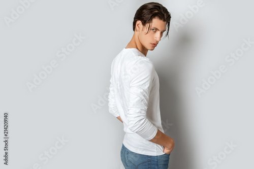Strong face male model in casual style in white t sirt and jeans on white background in studio isolated photo