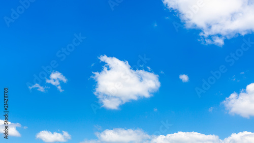 fluffy clouds in dark blue sky in sunny summer day