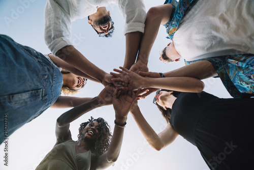 Excited friends holding hands together photo