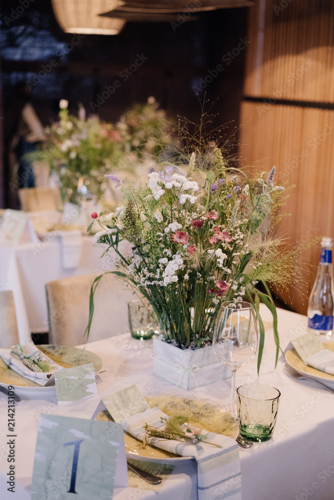 white vase with wildflowers on a festive table