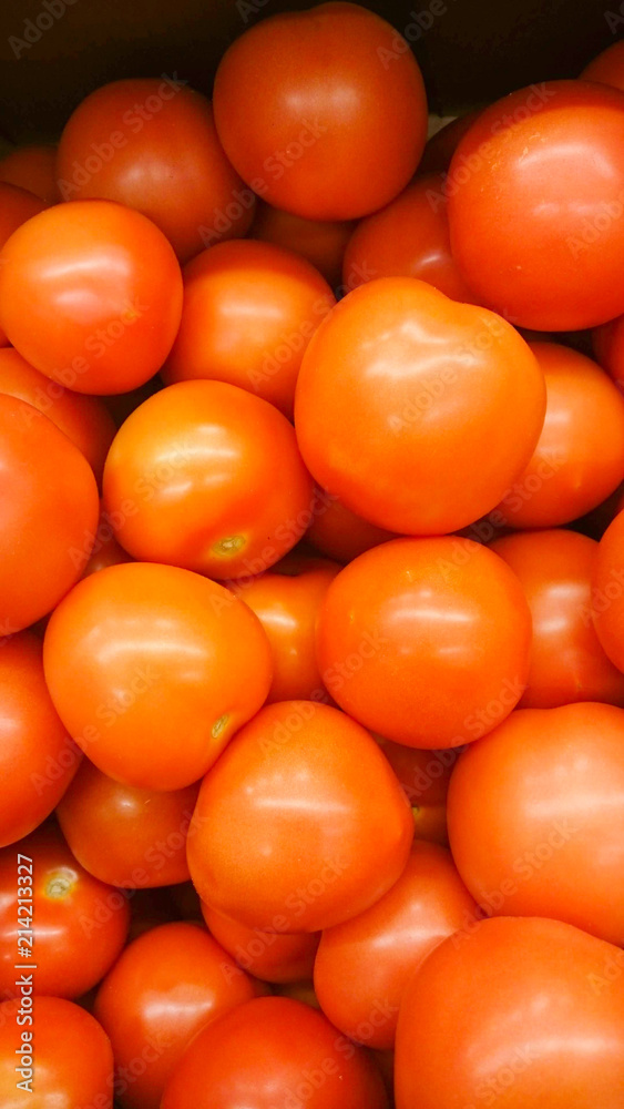 Vegetables are full of vitamins. Fresh and ripe tomatoes in a basket on a supermarket shelf Vegetables are full of vitamins. Fresh and ripe tomatoes in a basket on a supermarket shelf