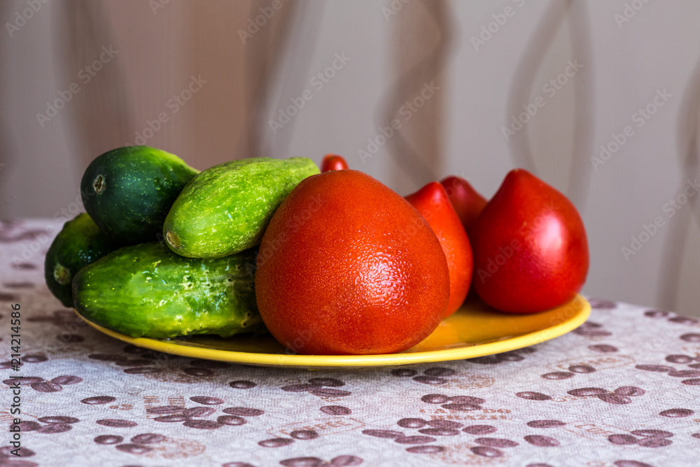 Juicy and tasty tomatoes with cucumbers on a plate Juicy and tasty tomatoes with cucumbers on a plate