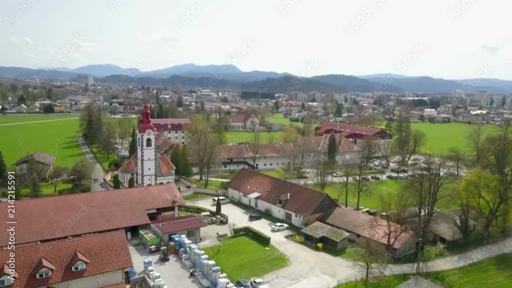 A church and some other buildings are situated on the edge of a town. Aerial shot. It's summer time. A church and some other buildings are situated on the edge of a town. Aerial shot. It's summer time.