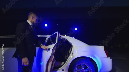 Group of rock musicians walking out of limo and giving autographs to fans while photographers taking shots on red carpet photo