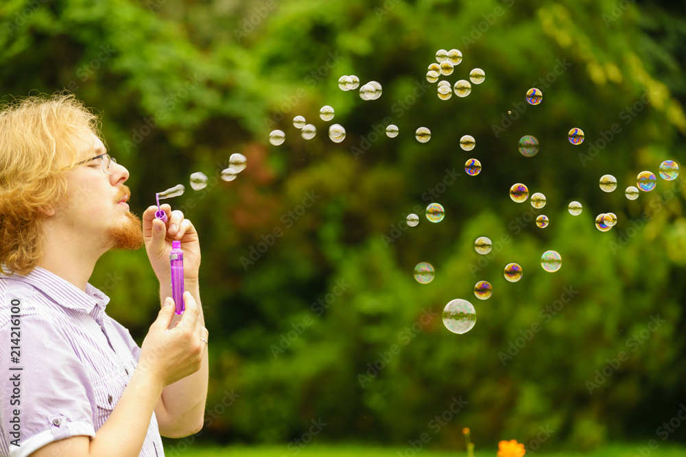 Man blowing soap bubbles outdoor