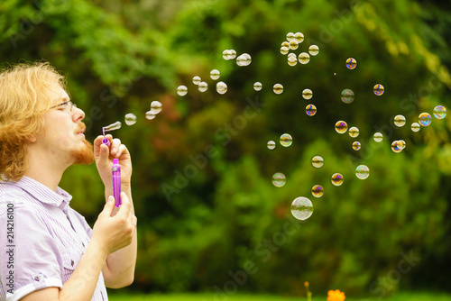 Man blowing soap bubbles outdoor