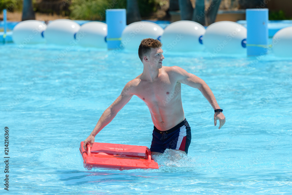 young man ride on a slide in a water park