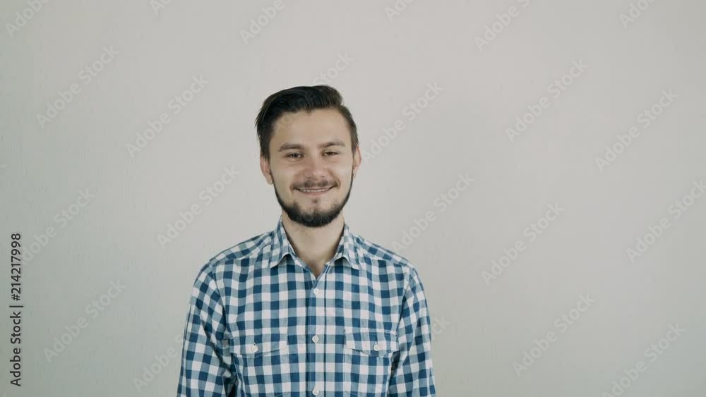 Portrait of happy young bearded man looking to the camera. Man standing against the wall. Portrait of happy young bearded man looking to the camera. Man standing against the wall.