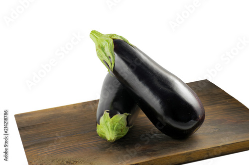 Two freshly picked eggplants on an old wooden surface.