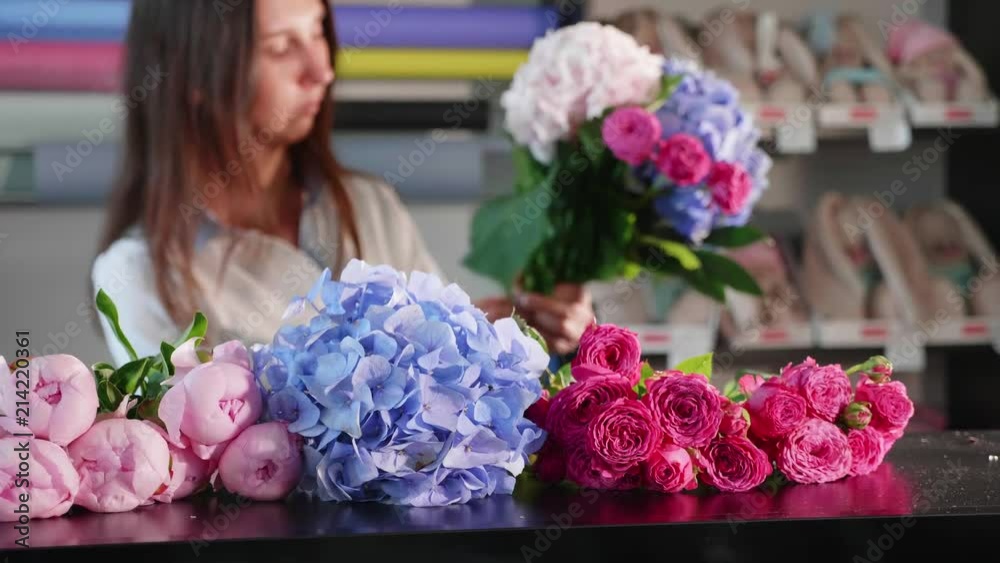 Florist girl makes a bouquet in a flower salon, close-up Florist girl makes a bouquet in a flower salon, close-up