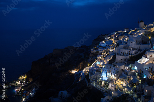 Whitewashed Houses and Windmill on Cliffs with Sea View at Night in Oia, Santorini, Cyclades, Greece