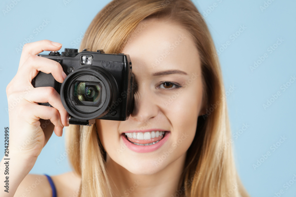 Blonde woman with camera on blue Blonde woman with camera on blue