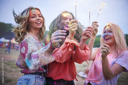 Three women holding sparklers at music festival photo