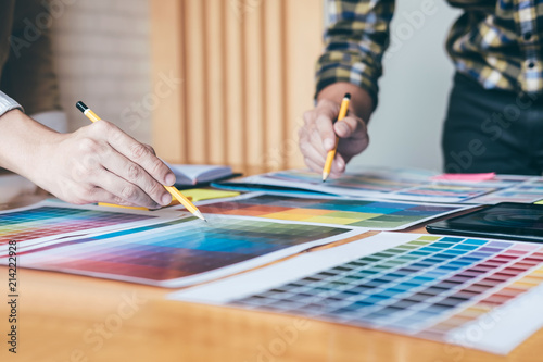 Young creative team having a meeting in creative office, Architectural drawing with work tools and accessories, Color swatch samples chart for selection coloring