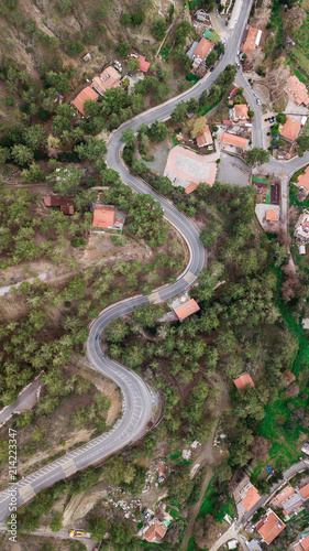 aerial view of curvy hill road surrounded with trees and houses, Cyprus