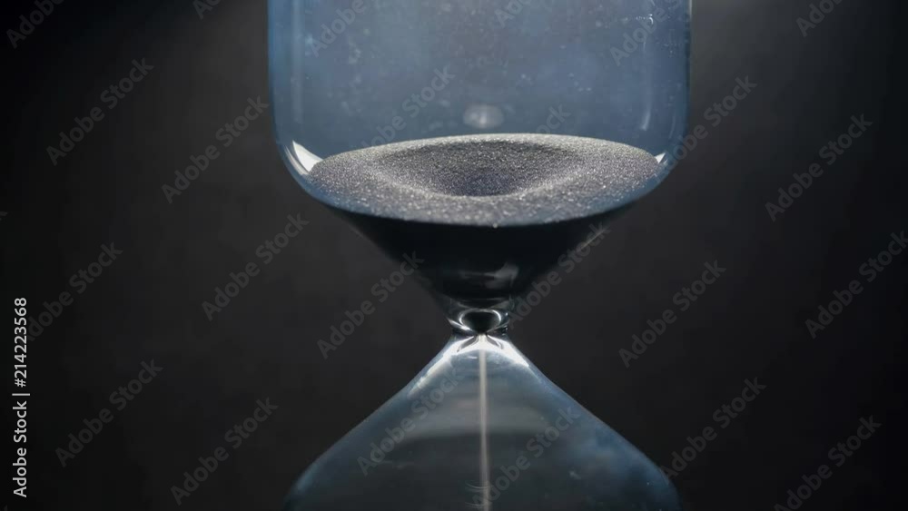 Sands move through hour glass. Close up.