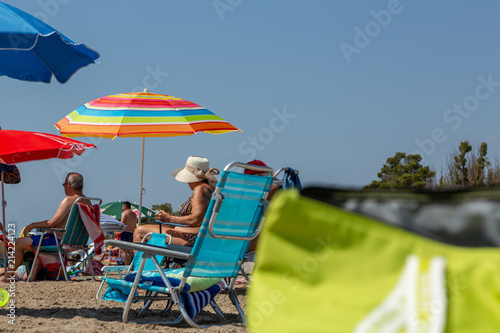 Solstolar och parasoller på sandstrand vid havet photo