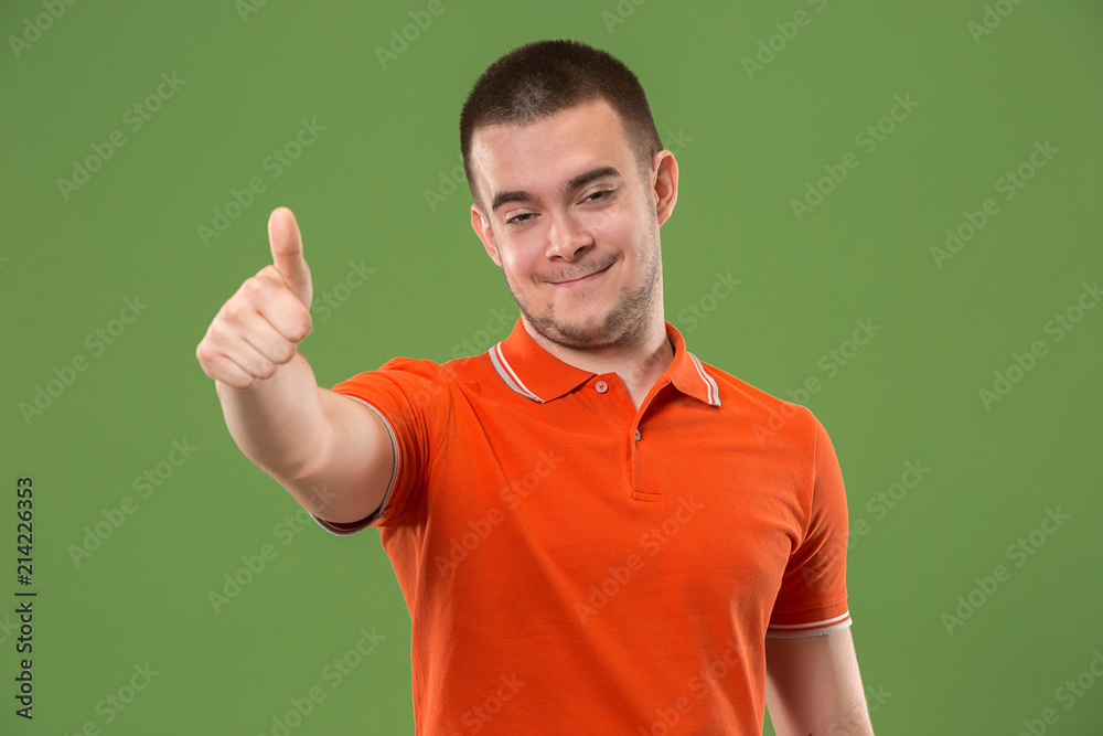The happy businessman standing and smiling against green background. The happy businessman standing and smiling against green background.