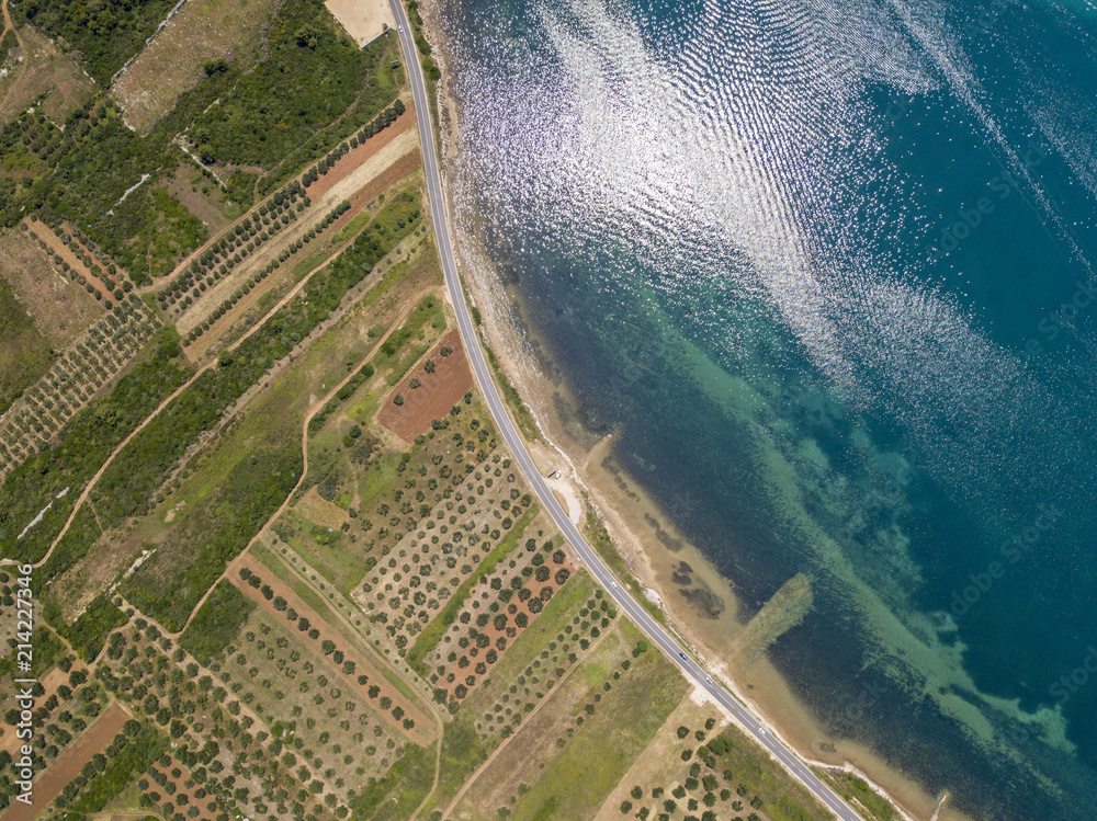 Foto de Vista aerea di una strada che costeggia la costa croata e attraversa campi agricoli, con Foto de Vista aerea di una strada che costeggia la costa croata e attraversa campi agricoli, con