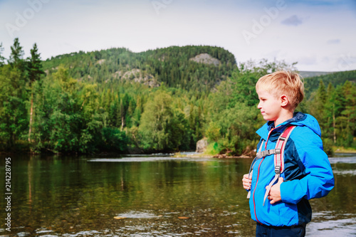 little boy with backpack hiking in nature