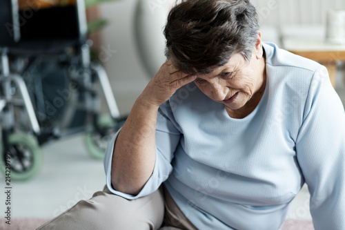 Grandmother with headache fell to the floor in the nursing house photo