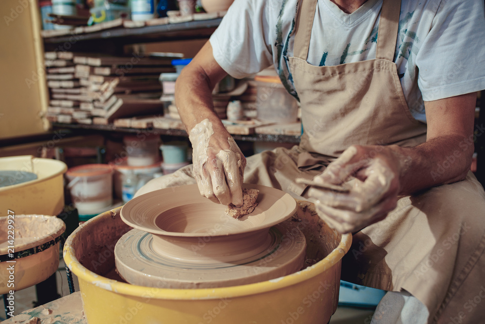 Creating a jar or vase of white clay close-up. Master crock. Man hands making clay jug macro. Creating a jar or vase of white clay close-up. Master crock. Man hands making clay jug macro.