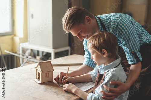 Smiling people with a wooden house