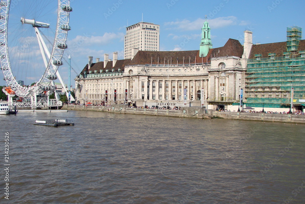 Landscape of the water surface of the River Thames against the background of a cloudy blue sky.