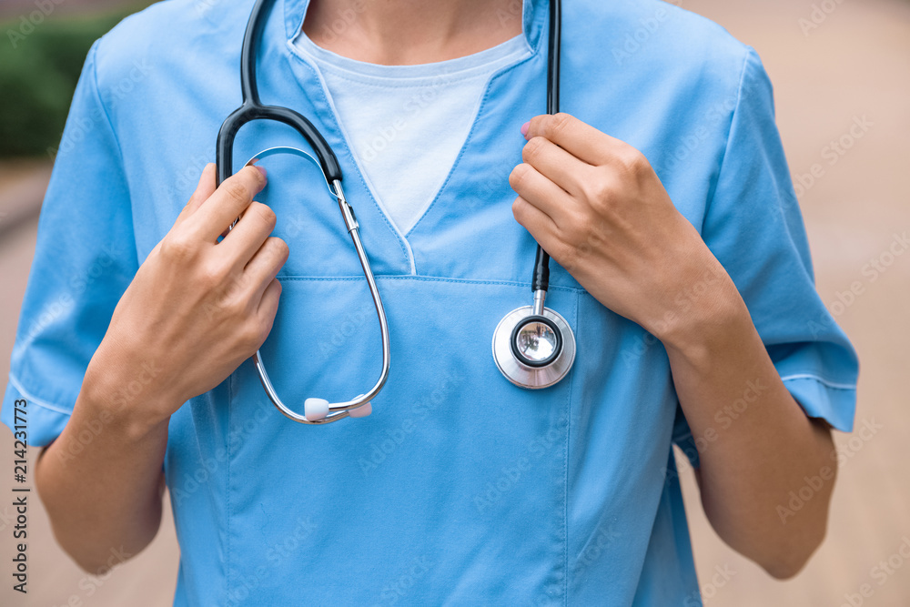 cropped image of medical student holding stethoscope on neck cropped image of medical student holding stethoscope on neck
