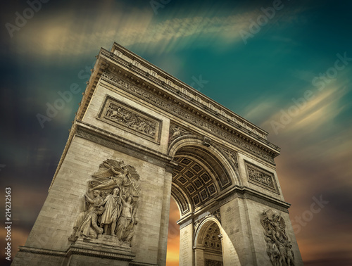 Arc de Triomphe in Paris under sky with clouds. One of symbols 