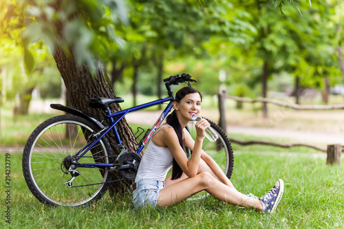 Teen girl with bicycle in a park. © Inna Vlasova