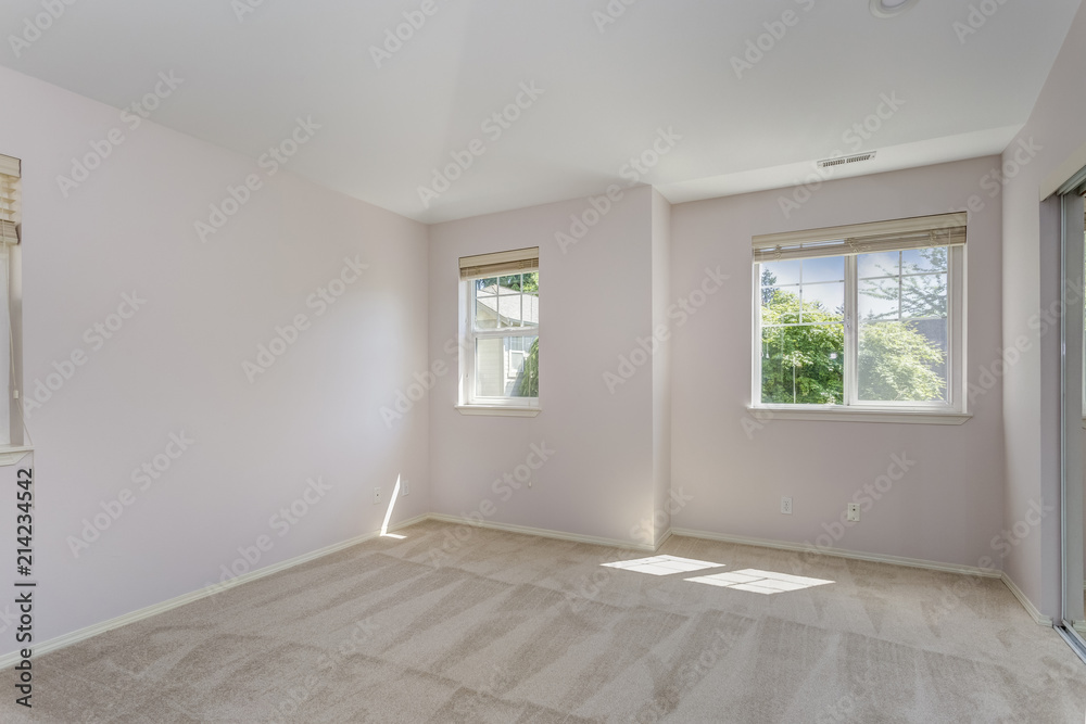 Fototapeta premium Empty sun filled bedroom with carpet floor.