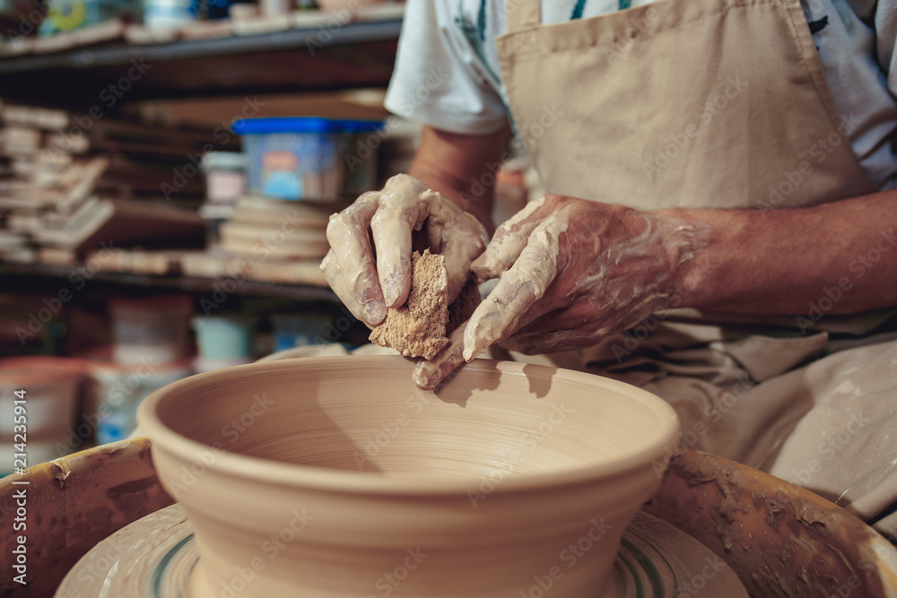 Creating a jar or vase of white clay close-up. Master crock. Man hands making clay jug macro.