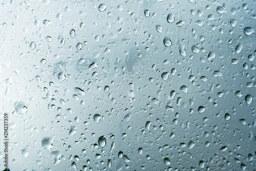 Textured background of window panes with a cloudy background. Natural pattern from a drop of rain on a cloudy background.