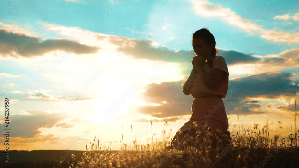 Girl lifestyle folded her hands in prayer silhouette at sunset. woman praying on her knees. slow motion video. Girl folded her hands in prayer pray to God. the girl praying asks forgiveness for sins Girl lifestyle folded her hands in prayer silhouette at sunset. woman praying on her knees. slow motion video. Girl folded her hands in prayer pray to God. the girl praying asks forgiveness for sins