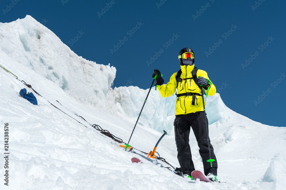 A freerider skier in complete outfit stands on a glacier in the North Caucasus