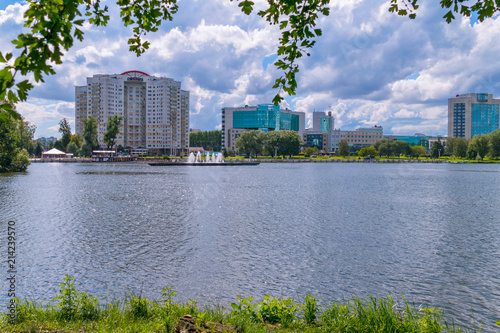 a panorama of a pond with fountains and to the opposite shore with new high-rise buildings