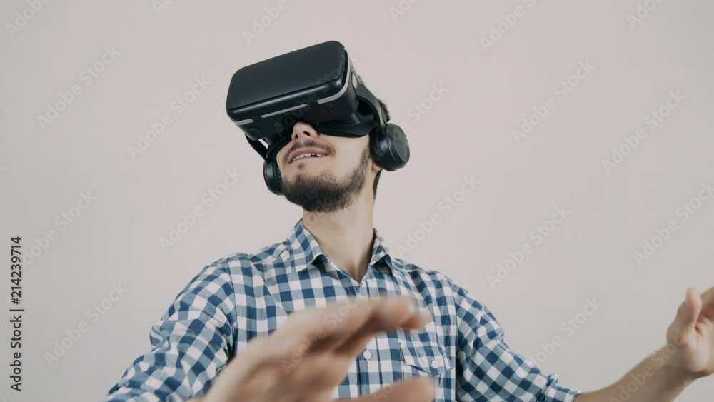 Close up shot of a young bearded man wearing virtual reality glasses - surfing net via virtual reality interface. Close up shot of a young bearded man wearing virtual reality glasses - surfing net via virtual reality interface.