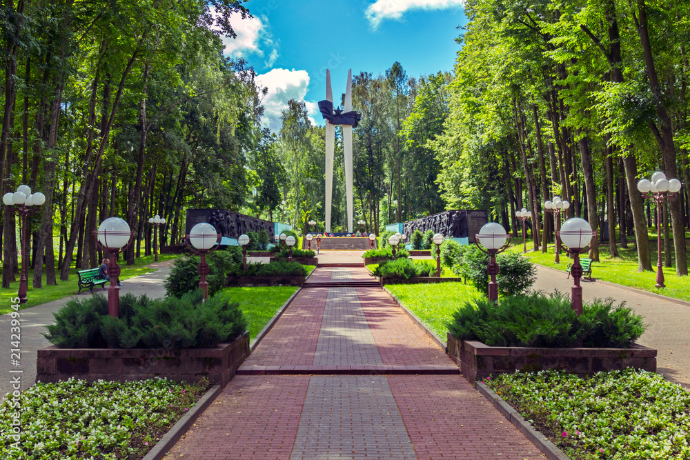 a track with plantings of bushes and lanterns by bullets on the sides, leads to the monument of the memorial