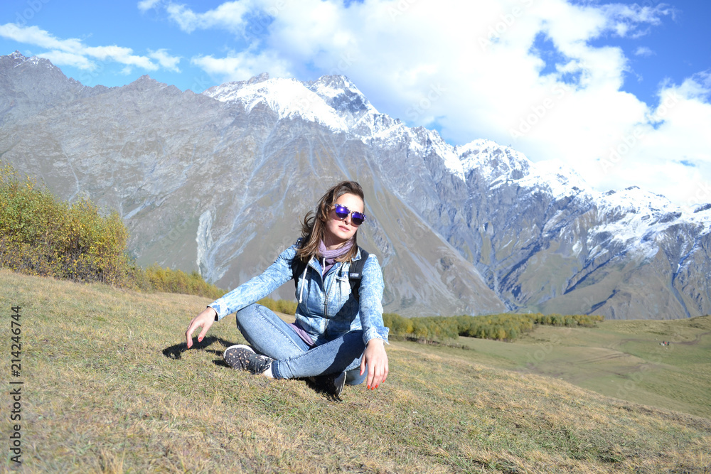 Naklejka premium Woman in sunglasses looking into camera in front of Kazbegi mountains, Georgia